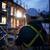 Person mit Helm und Kabel auf Baustelle