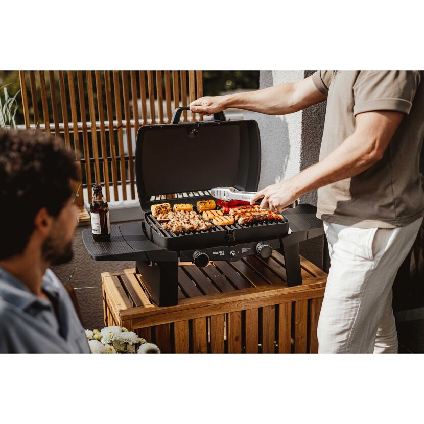 Person grillt mit Grillzange auf Gasgrill