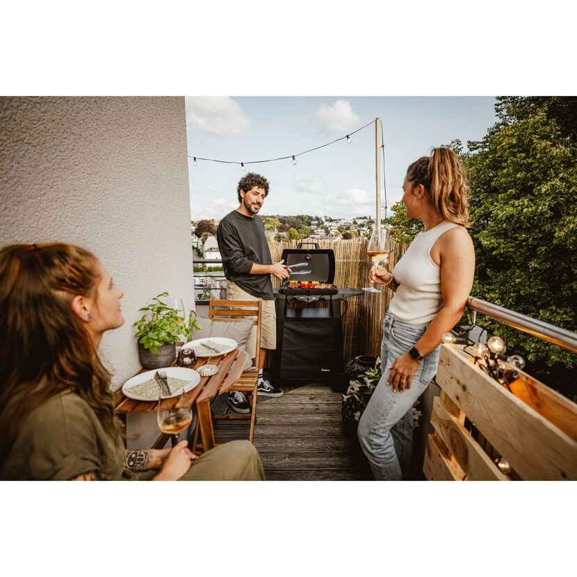 Drei Personen grillen auf einem Balkon
