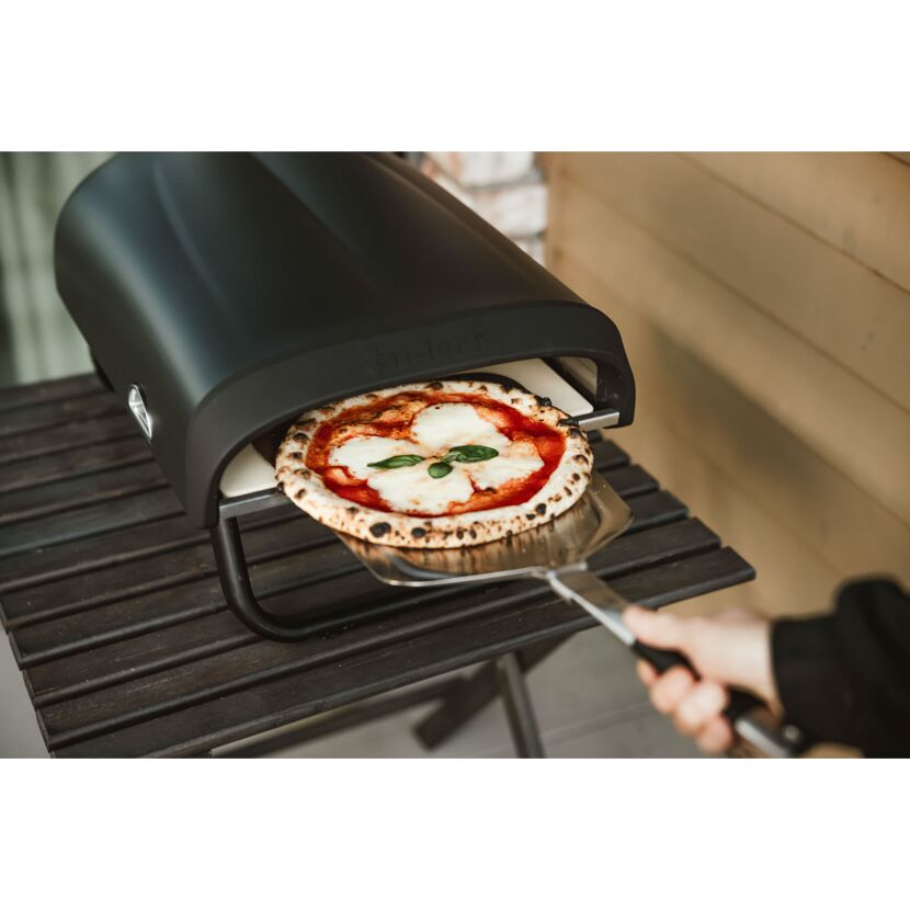 Pizza wird aus Pizzaofen geholt