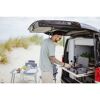Person kocht auf Campingkocher am Strand