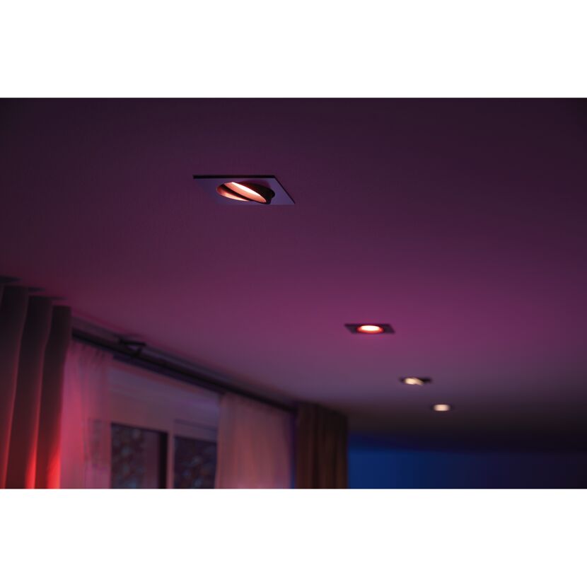 LED-Einbauspots von Hue leuchten rot in der Decke.