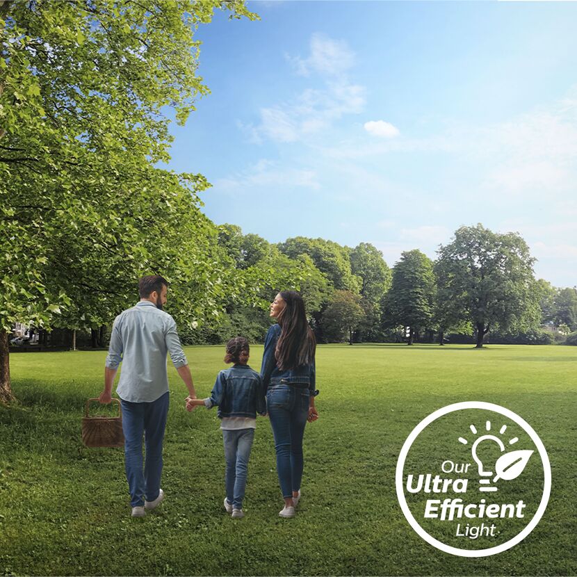 Familie spaziert durch grünen Park, mit Logo.