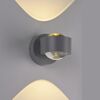 LED-Spot 'Chia' leuchtet warmes Licht an grauer Wand.