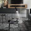 Schwarze LED-Tischleuchte 'Rik' beleuchtet Magazin im Wohnzimmer.