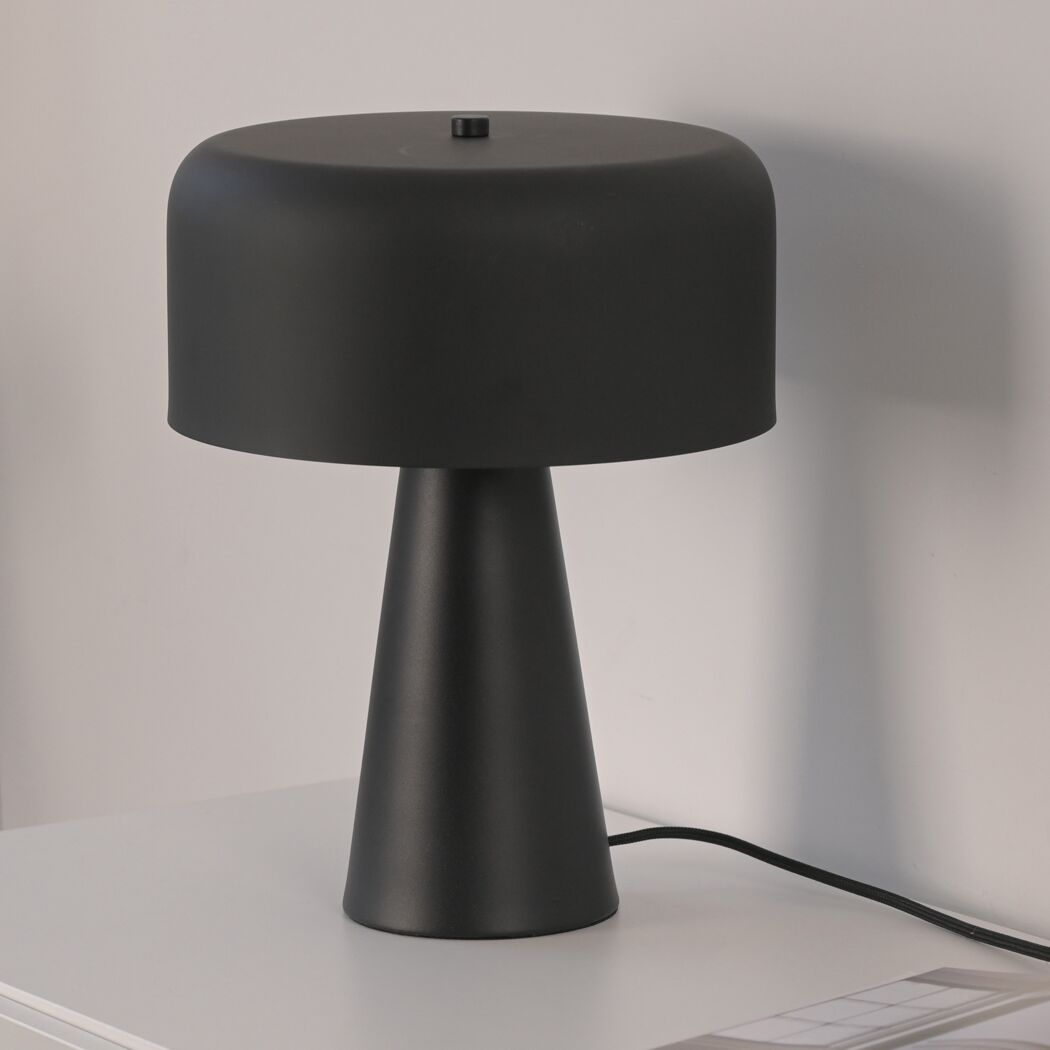 Schwarze Tischleuchte 'Pento' auf weißem Regal.