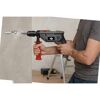 Person bohrt mit 900W Schlagbohrmaschine in eine Wand.
