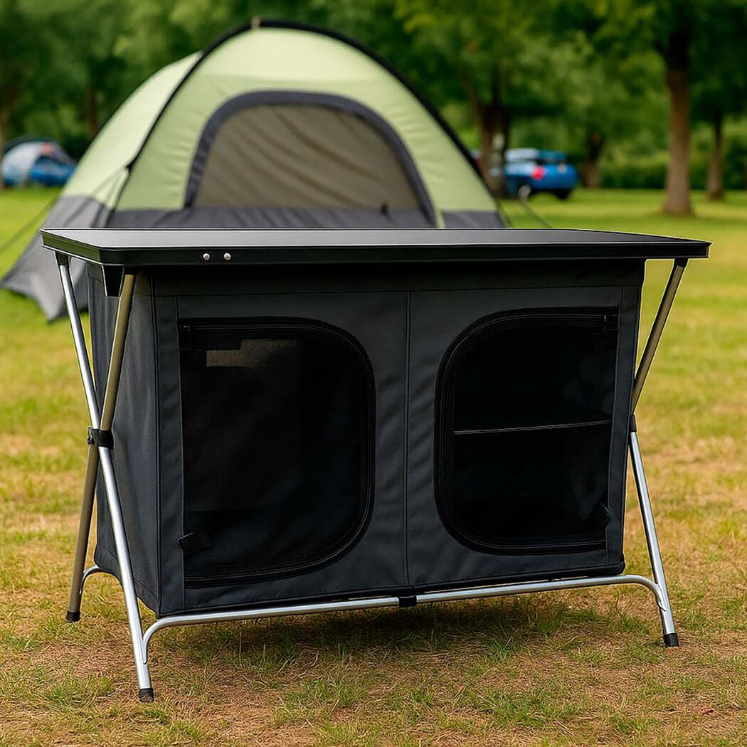 Schwarzer klappbarer Campingschrank vor Zelt auf Gras