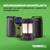 Drei Thermacell Mückenabwehrgeräte und Laterne auf grünem Hintergrund.