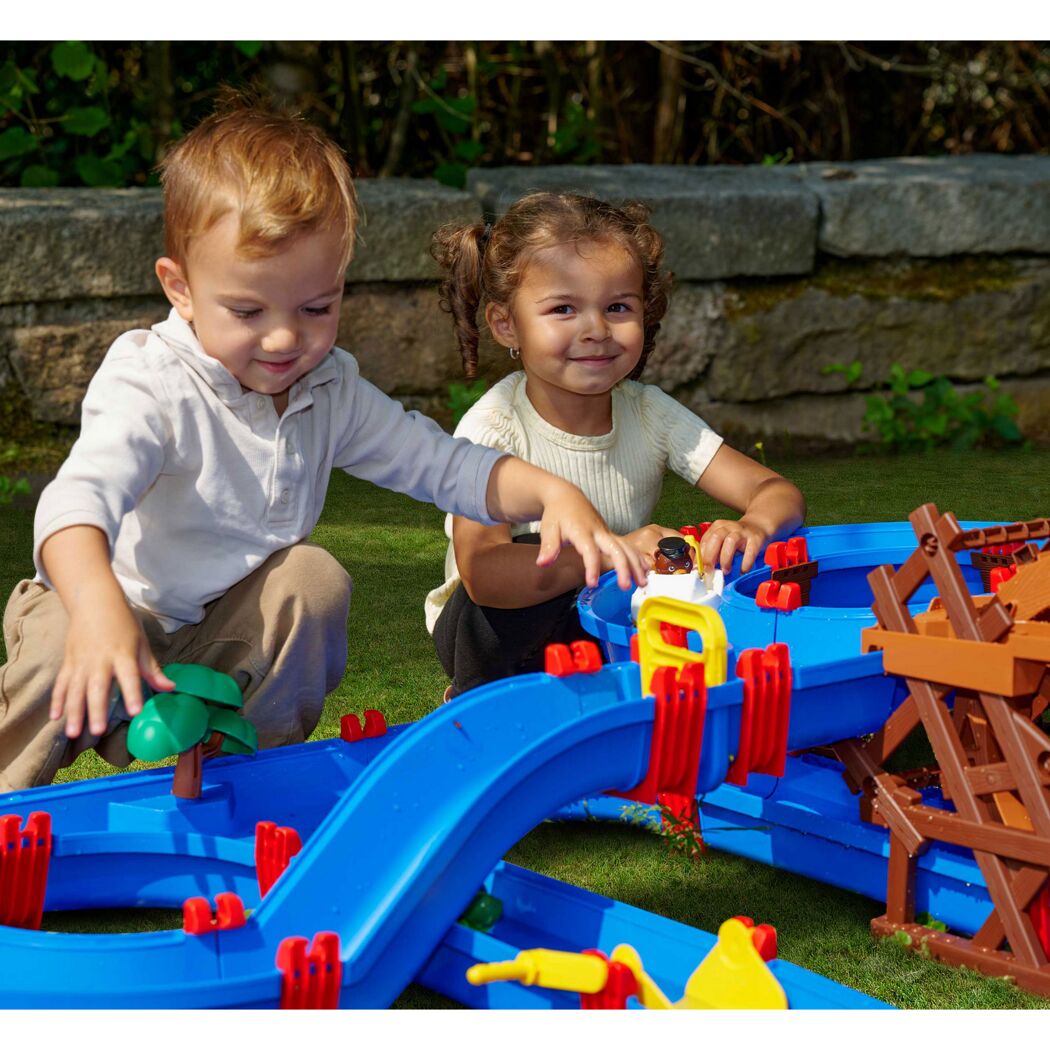 Zwei Kinder spielen mit der farbigen Wasserbahn 'WaterWheel'.