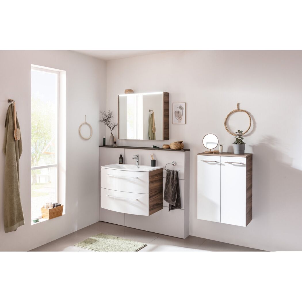Badezimmer mit Waschtisch, Spiegel und Midischrank in Nussbaum und Weiß.