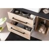 Badschrank mit hellen Holzschubladen und schwarzen Griffleisten.