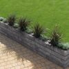 Mauerstein 'T-Wall Linear' quarzit als Hochbeet mit Pflanzen und Rasen.