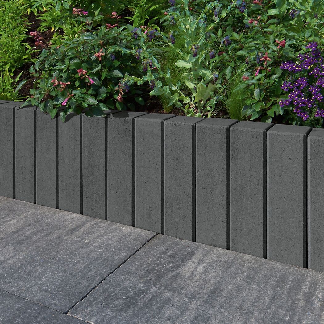 Mauerstein 'T-Wall Fine' basaltfarben als Beeteinfassung.