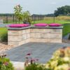 Mauerstein 'T-Wall Linear Maxi' als Gartenmauer mit pinken Kissen