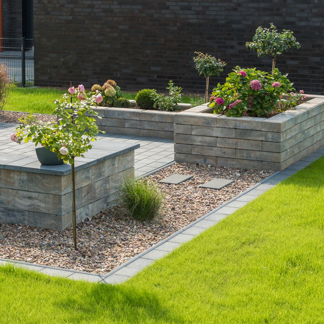 Gartenanlage mit muschelkalkfarbenen Mauersteinen 'T-Wall Linear Maxi'.