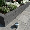 Mauerstein 'T-Wall Shine Pico' als Hochbeet mit Blumen und Gießkanne.