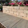 Sandsteinfarbene 'T-Wall Aged Small' Mauersteine mit Blumenbeet.