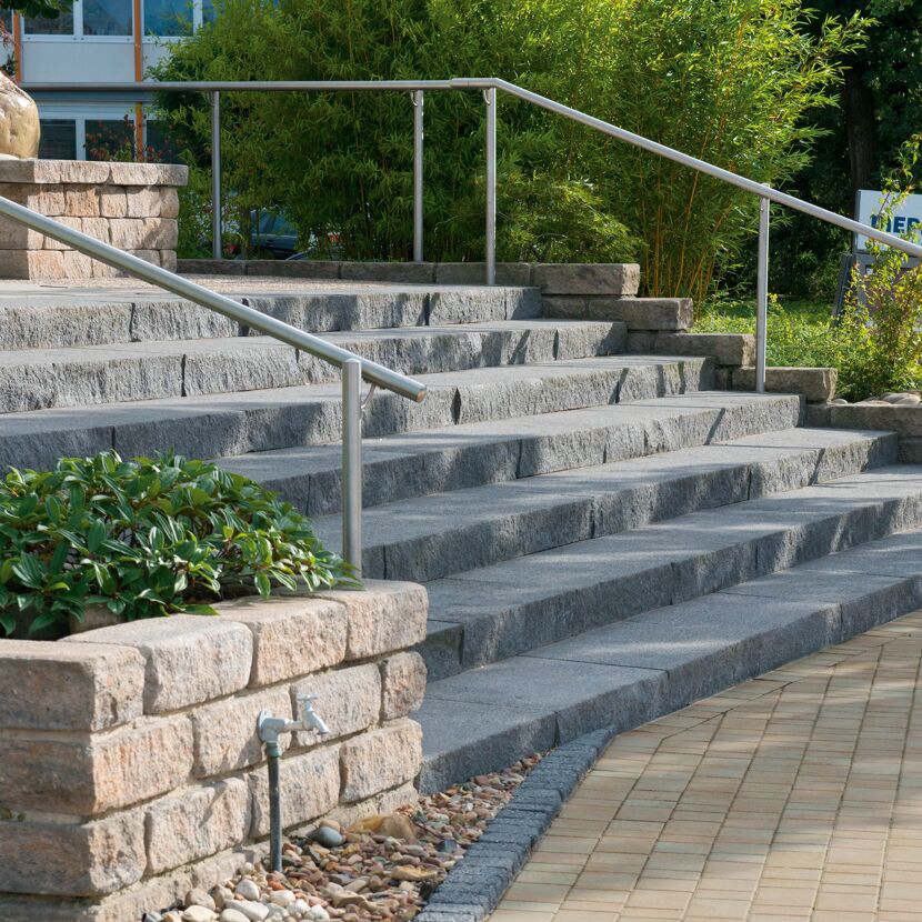 Schwarze Blockstufen-Treppe 'T-Stair Quarry' mit Geländer im Außenbereich.