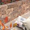 Mauerstein 'T-Wall Aged Midi' mit Kissen und Herbstlaub.