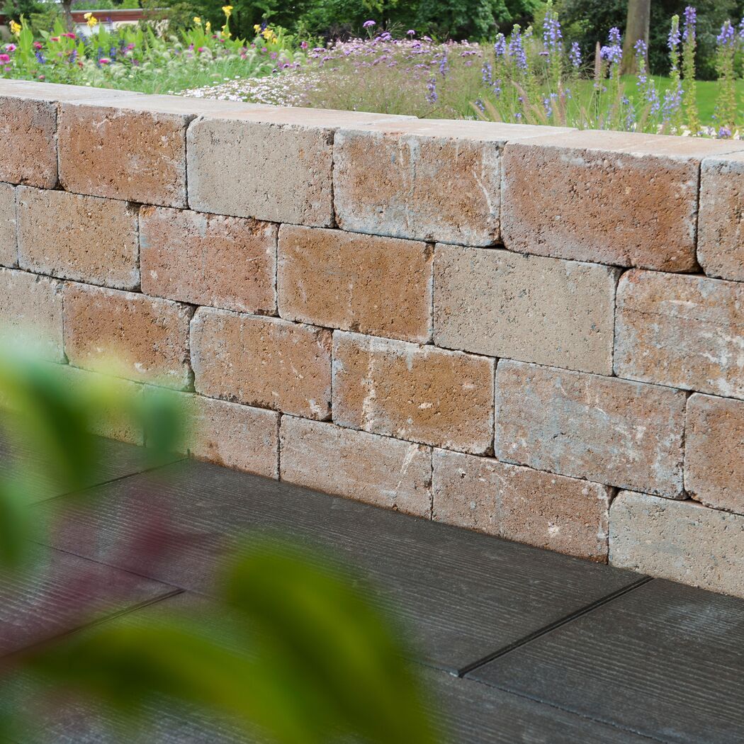 Sandsteinfarbene Mauer 'T-Wall Aged Big' im Garten.