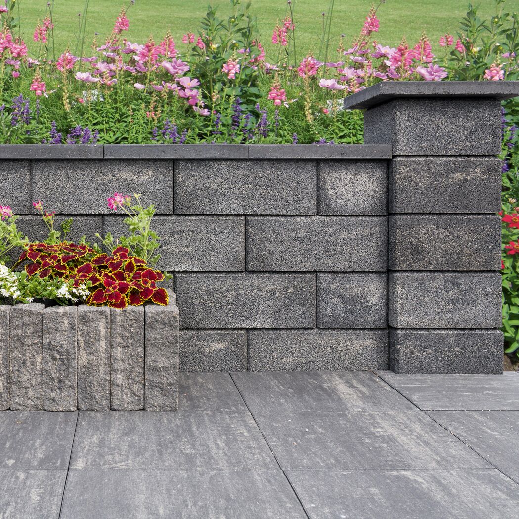 Mauerstein 'T-Wall System' quarzit Wand und Pflanzkübel im Garten.