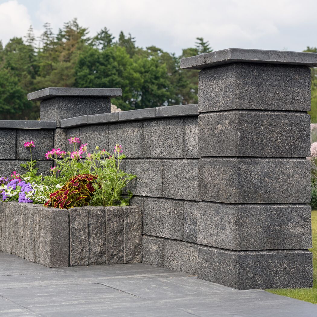 Mauerstein 'T-Wall System' mit farbigem Blumenbeet im Garten