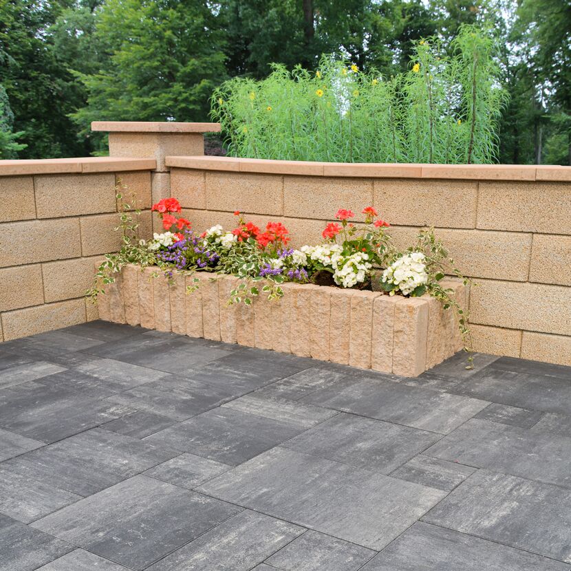 Mauerstein 'T-Wall System' sandsteinfarben als Hochbeet mit bunten Blumen