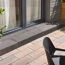 Basaltfarbene Blockstufe 'T-Stair Shine' vor einer Fenstertür.