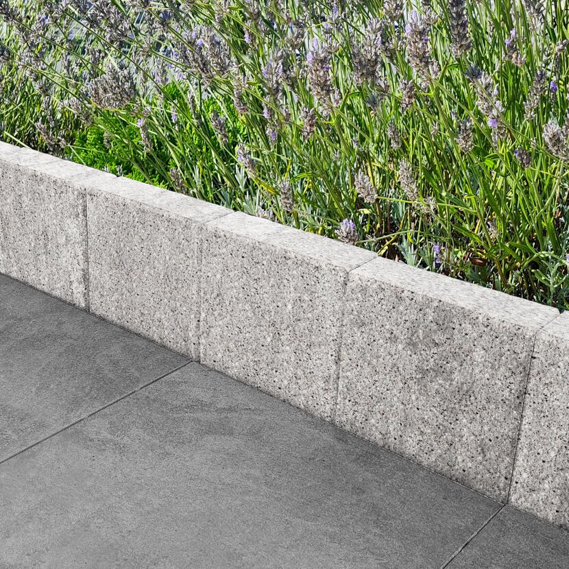 Granitfarbene Palisade 'T-Gravity Shine' trennt Pflaster und Lavendel