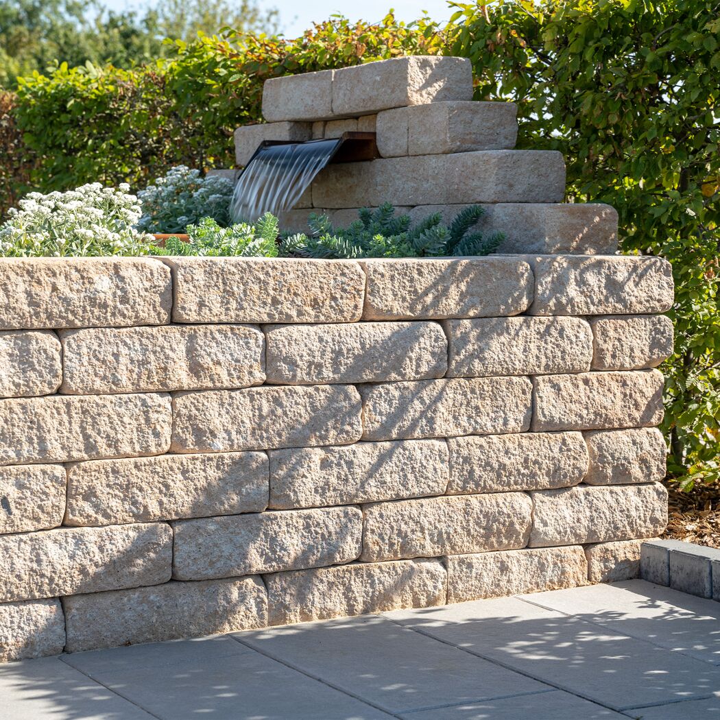 Sandsteinfarbene Mauersteine 'T-Wall Quarry Big' mit Garten-Wasserfall.