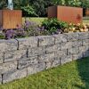 Mauerstein 'T-Wall Quarry Middle' als Gartenmauer mit Blumen.