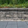 Mauerstein 'T-Wall Quarry Block' im Garten mit Blumenbeet.
