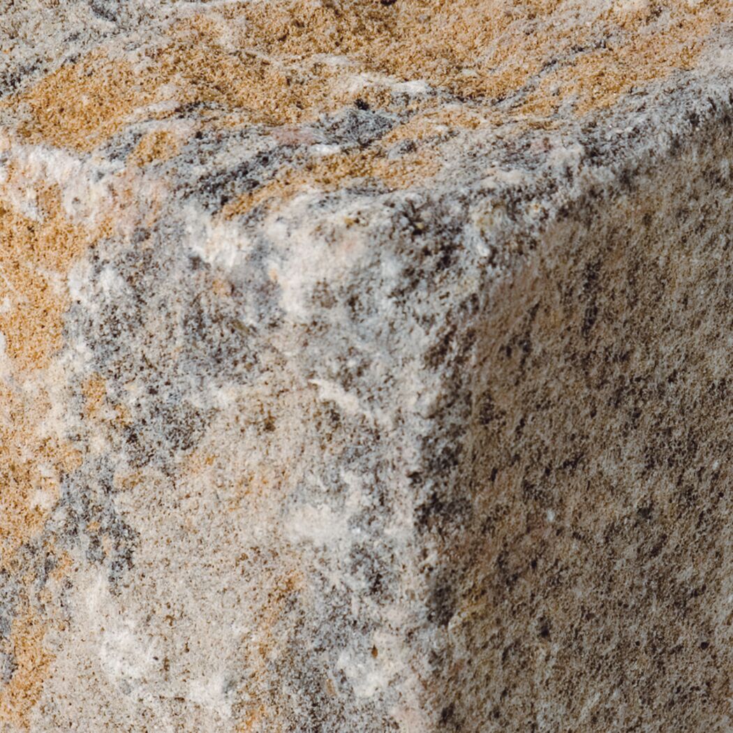 Detailansicht muschelkalkfarbener Mauerstein mit rauer Oberfläche.