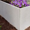 Graue Palisade mit lila Blumen bepflanzt