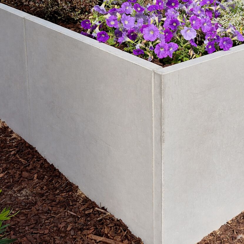 Graue Palisade mit lila Blumen bepflanzt