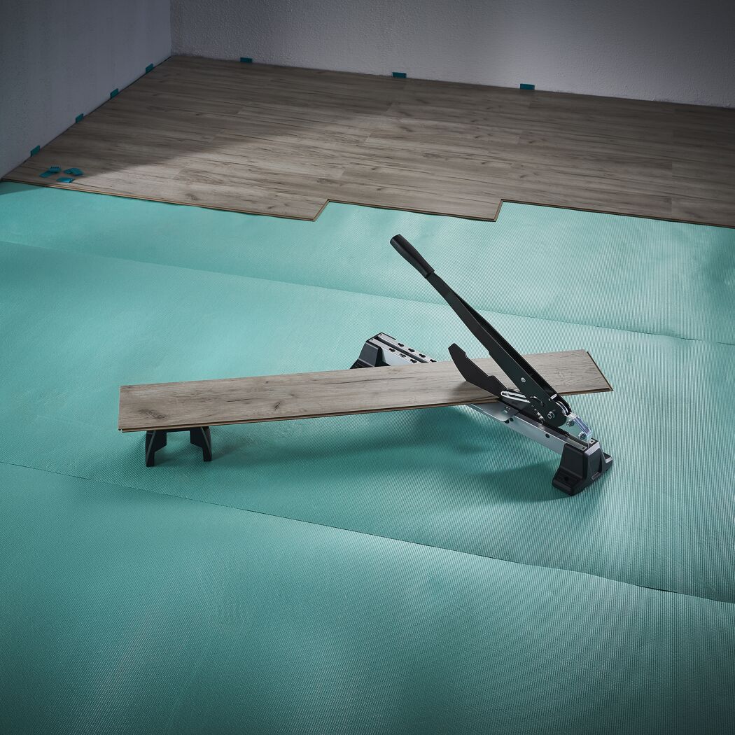 Person schneidet Laminat mit Laminatschneider.