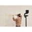 Person bringt mit Kreuzlinienlaser Klebeband an Wand an