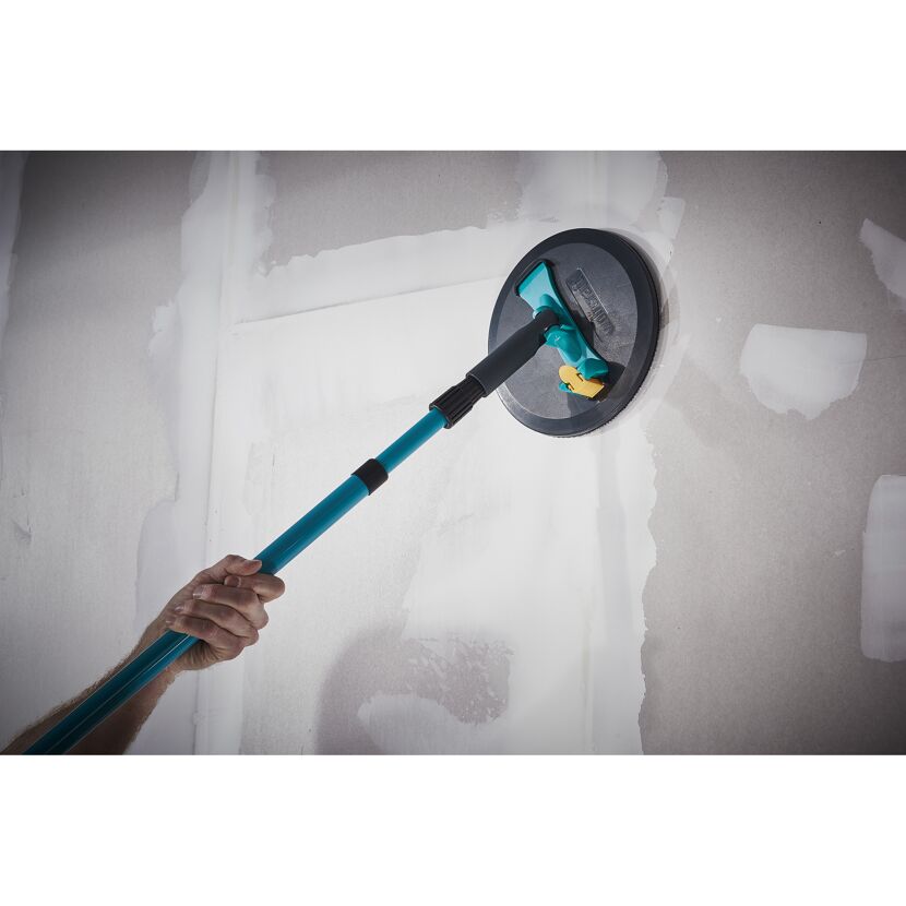 Person schleift Wand mit Schleifgerät