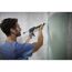 Person verwendet Kartuschenpresse zum Verfugen einer Wand