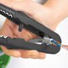 Hand verwendet Abisolierzange für Kabel.