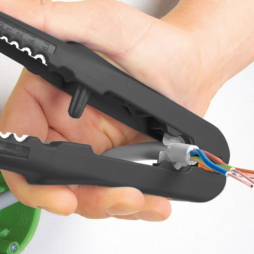 Hand verwendet Abisolierzange für Kabel.