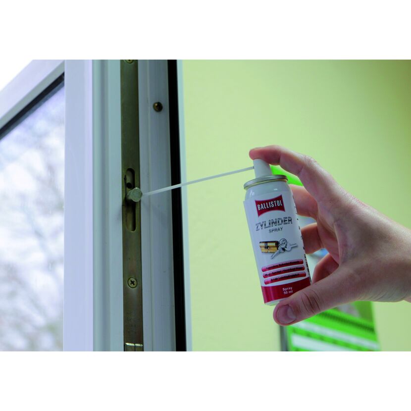 Person ölt mit Ballistol Zylinder-Spray einen Türbeschlag.