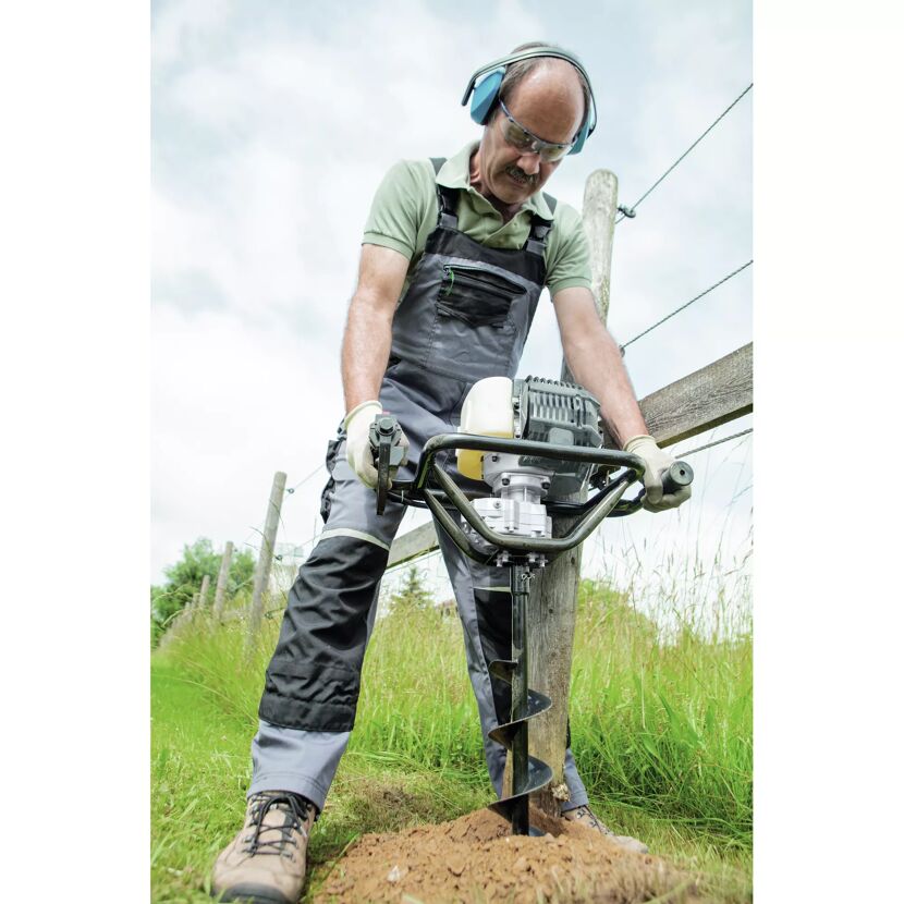 Person bohrt mit Erdbohrer in die Erde