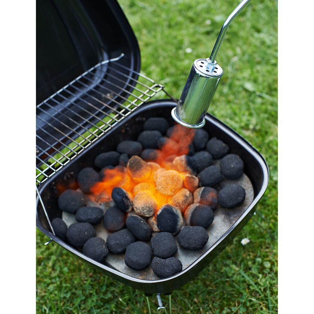 Grillkohle wird mit einem Abflammgerät entzündet