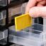 Person ordnet gelbes Etikett in VarioPlus Basic 54 Kleinteilemagazin ein