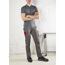 Person in grauer Arbeitskleidung mit roten Details