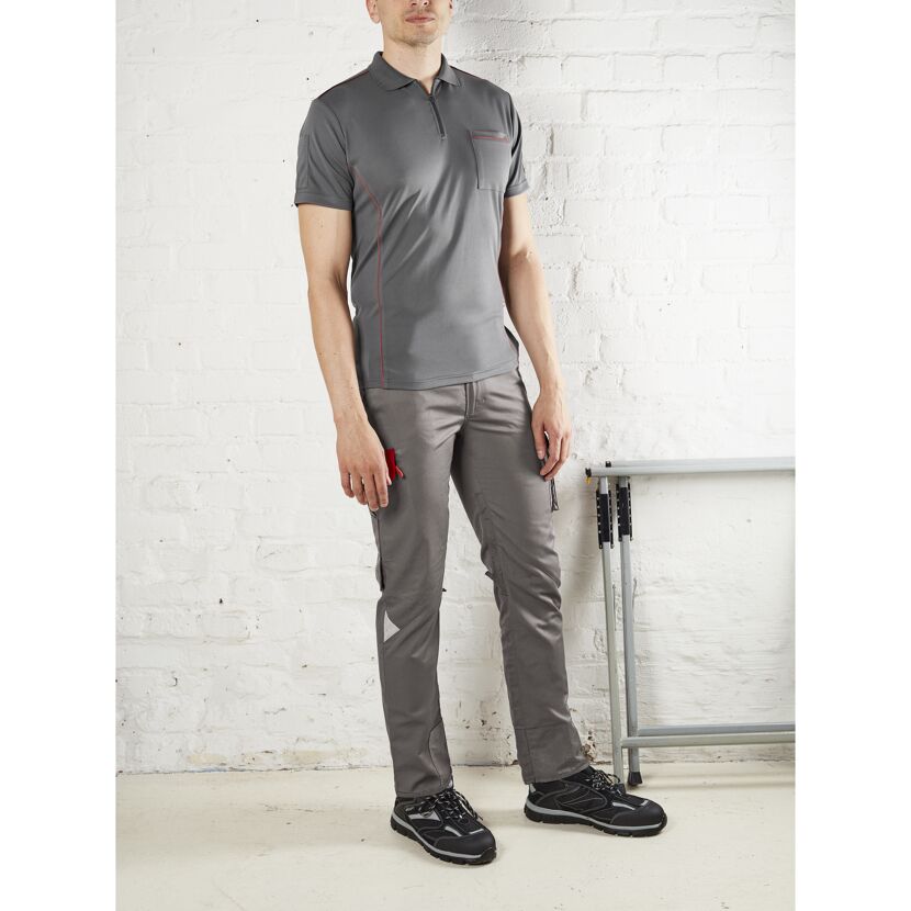Person trägt graues Poloshirt, Hose und Sicherheitsschuhe