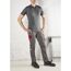 Person in grauer Arbeitskleidung mit roten Details