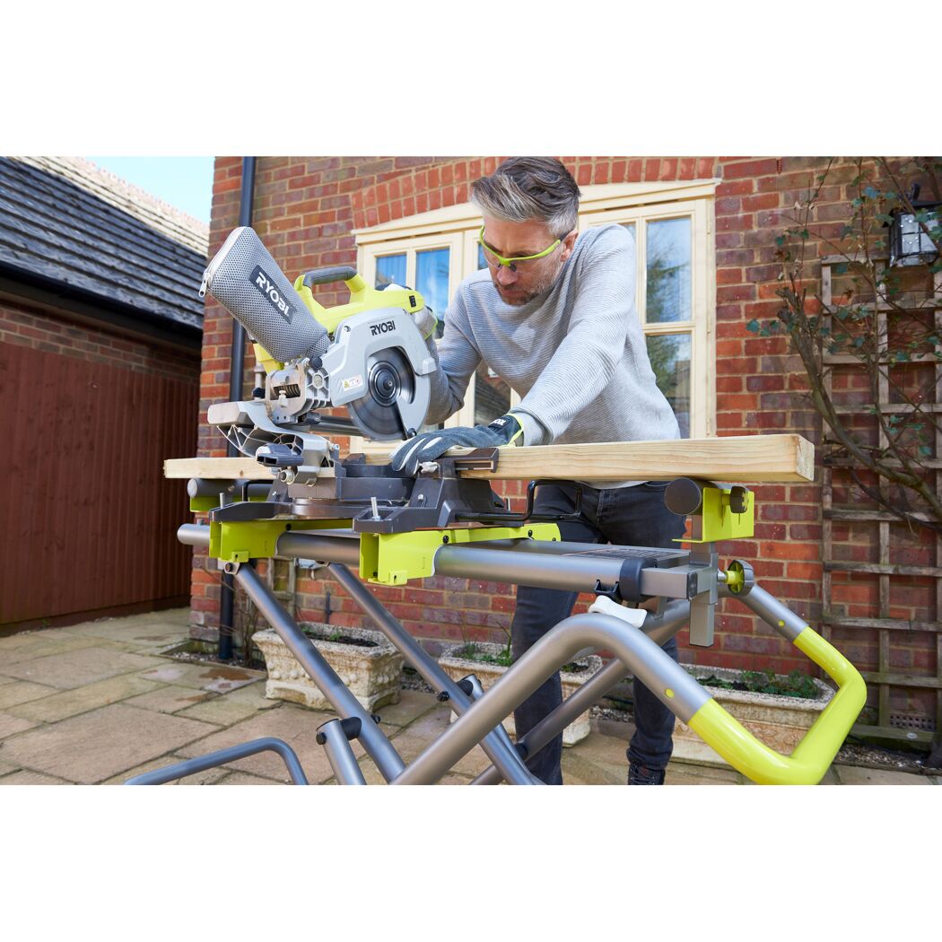 Person sägt Holz mit Ryobi Kappsäge auf Untergestell